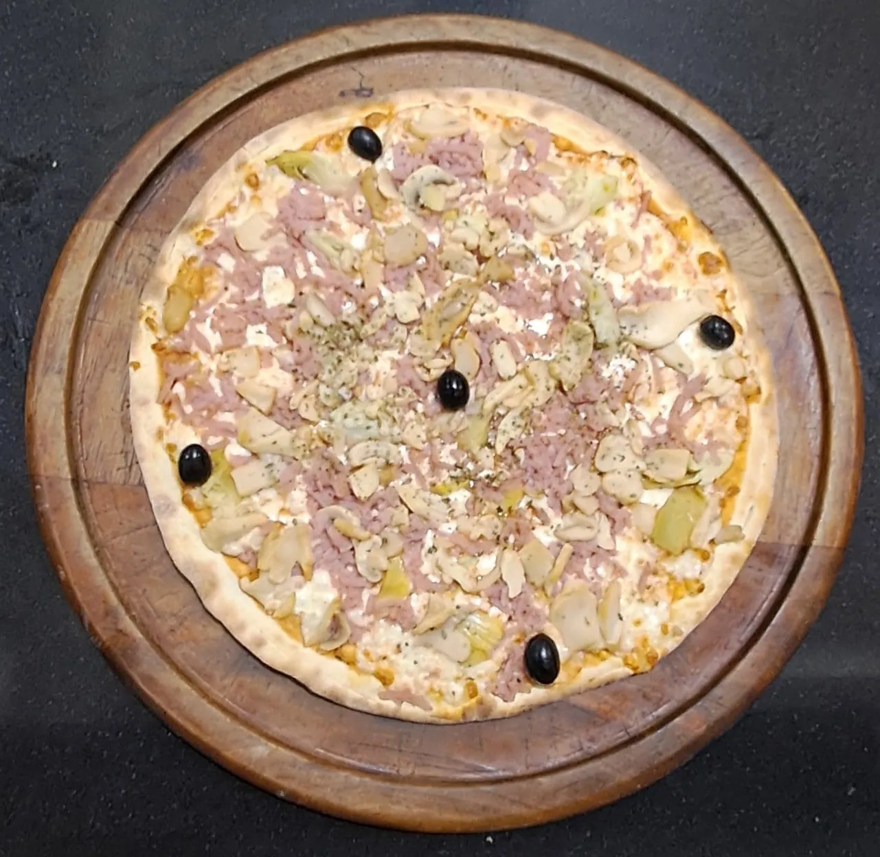 Pizza Capricciosa com fiambre, alcachofra e cogumelos, fotografada pelo restaurante